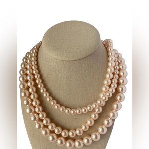 Pale pink faux pearl multi strand necklace.